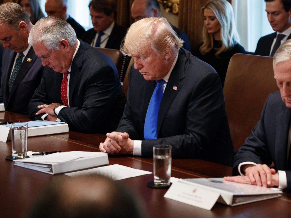 President Donald Trump prays during a cabinet meeting at the White House, Wednesday, Dec. 20, 2017, in Washington. From left, Secretary of Interior Ryan Zinke, Secretary of State Rex Tillerson, Trump, and Secretary of Defense Jim Mattis.