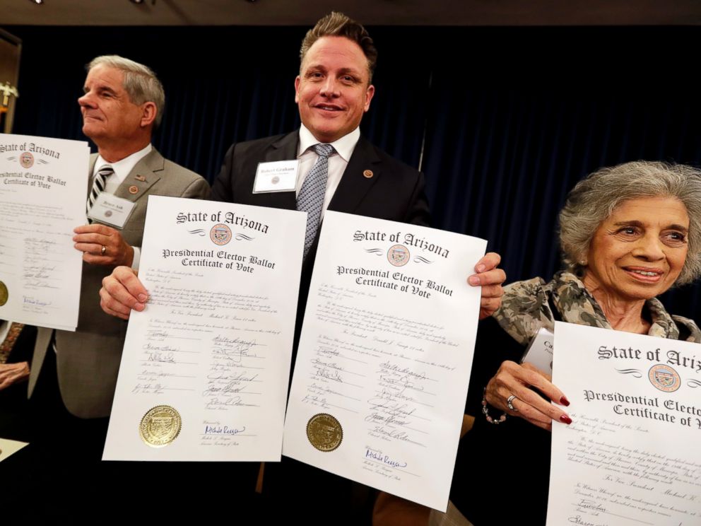 PHOTO: Arizona Electoral College members Bruce Ash, Robert Graham and Carol Joyce, display their ballots for president-elect Donald Trump at the Capitol in Phoenix, Dec. 19, 2016. All 11 Arizona members cast their vote for Trump.