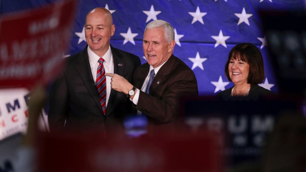 Mike Pence, and his wife Karen, stand on stage with Nebraska Governor Pete Ricketts before speaking at a campaign stop in Omaha, Oct. 27, 2016.