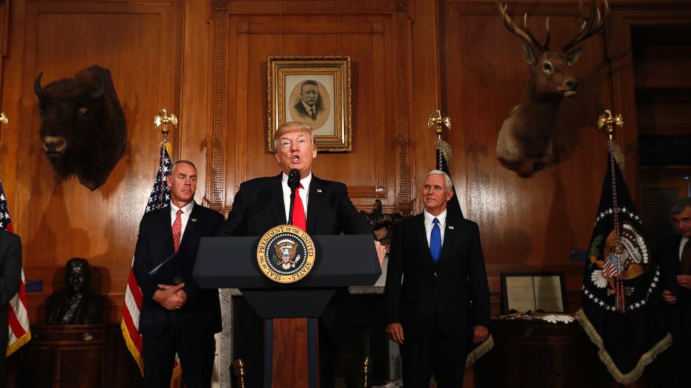 President Donald Trump, flanked by Interior Secretary Ryan Zinke, left, and Vice President Mike Pence, speaks at the Interior Department in Washington, April 26, 2017, before  signing an Antiquities Executive Order. The president is asking for a review of the designation of tens of millions of acres of land as "national monuments." 