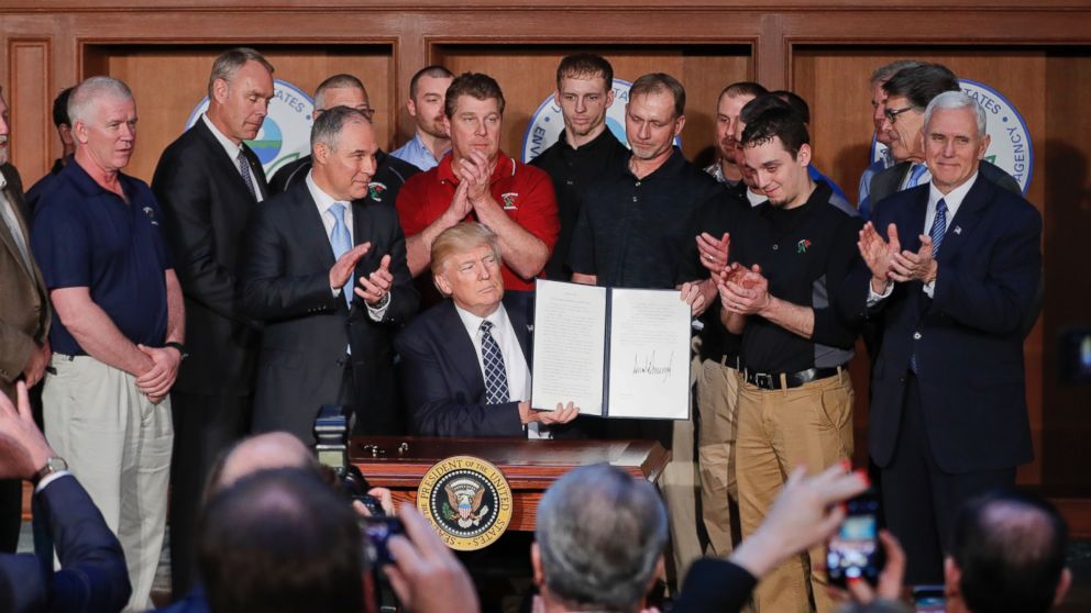 PHOTO: President Donald Trump, accompanied by Environmental Protection Agency (EPA) Administrator Scott Pruitt, third from left, applaud as he holds up the signed Energy Independence Executive Order, March 28, 2017, at EPA headquarters in Washington.