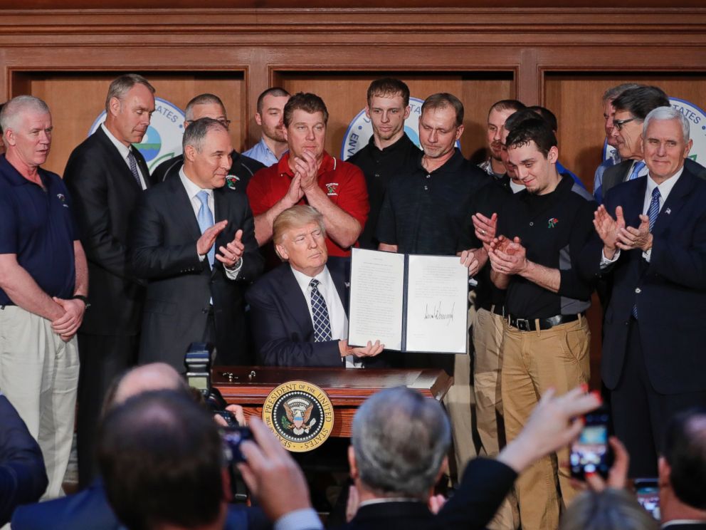 PHOTO: President Donald Trump, accompanied by Environmental Protection Agency (EPA) Administrator Scott Pruitt, third from left, applaud as he holds up the signed Energy Independence Executive Order, March 28, 2017, at EPA headquarters in Washington.