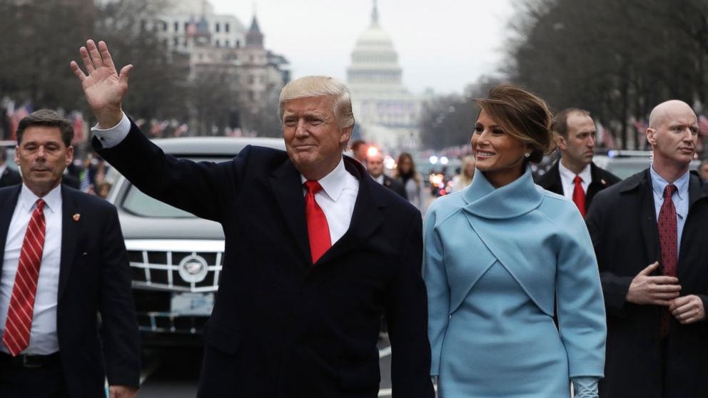 President Donald Trump waves as he walks with First Lady Melania Trump during the inauguration parade on Pennsylvania Avenue in Washington, Jan. 20, 2017.