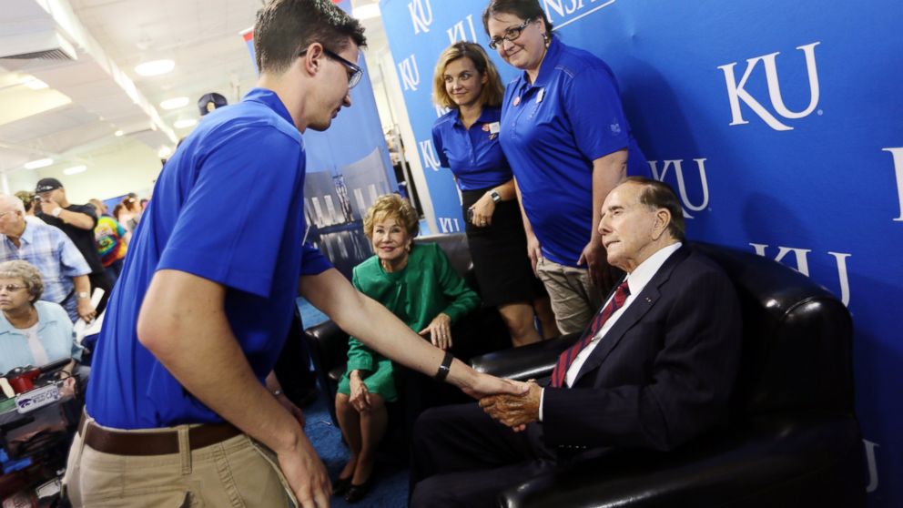 Cody Christensen, with the Dole Institute, shakes hands with Bob Dole at the KU booth in the Meadowlark Building at the Kansas State Fair, Sept. 7, 2014, in Hutchinson, Kan.
