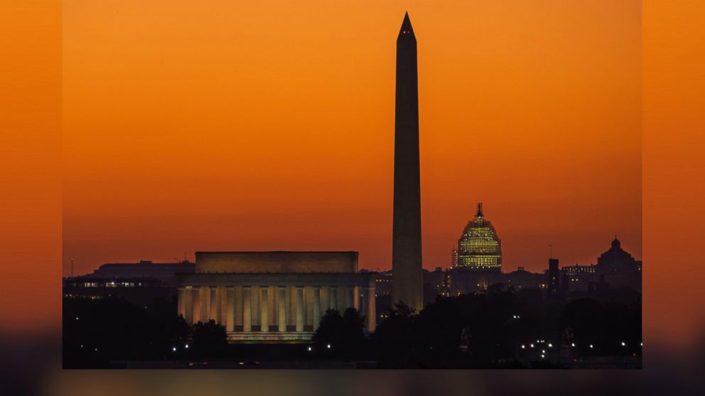 The orange sky of sunrise is captured behind the skyline of Washington, Sept. 8, 2015, on the first day back to work for the U.S. Congress after their summer recess.