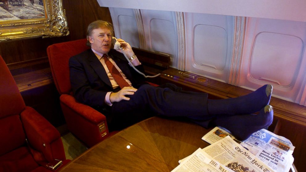 PHOTO: Donald Trump uses the phone and puts his sock-covered feet on the table in his private plane as he flies to Minnesota for a speech and to attend a fund-raiser for Gov. Jesse Ventura, Friday Jan. 7, 2000.