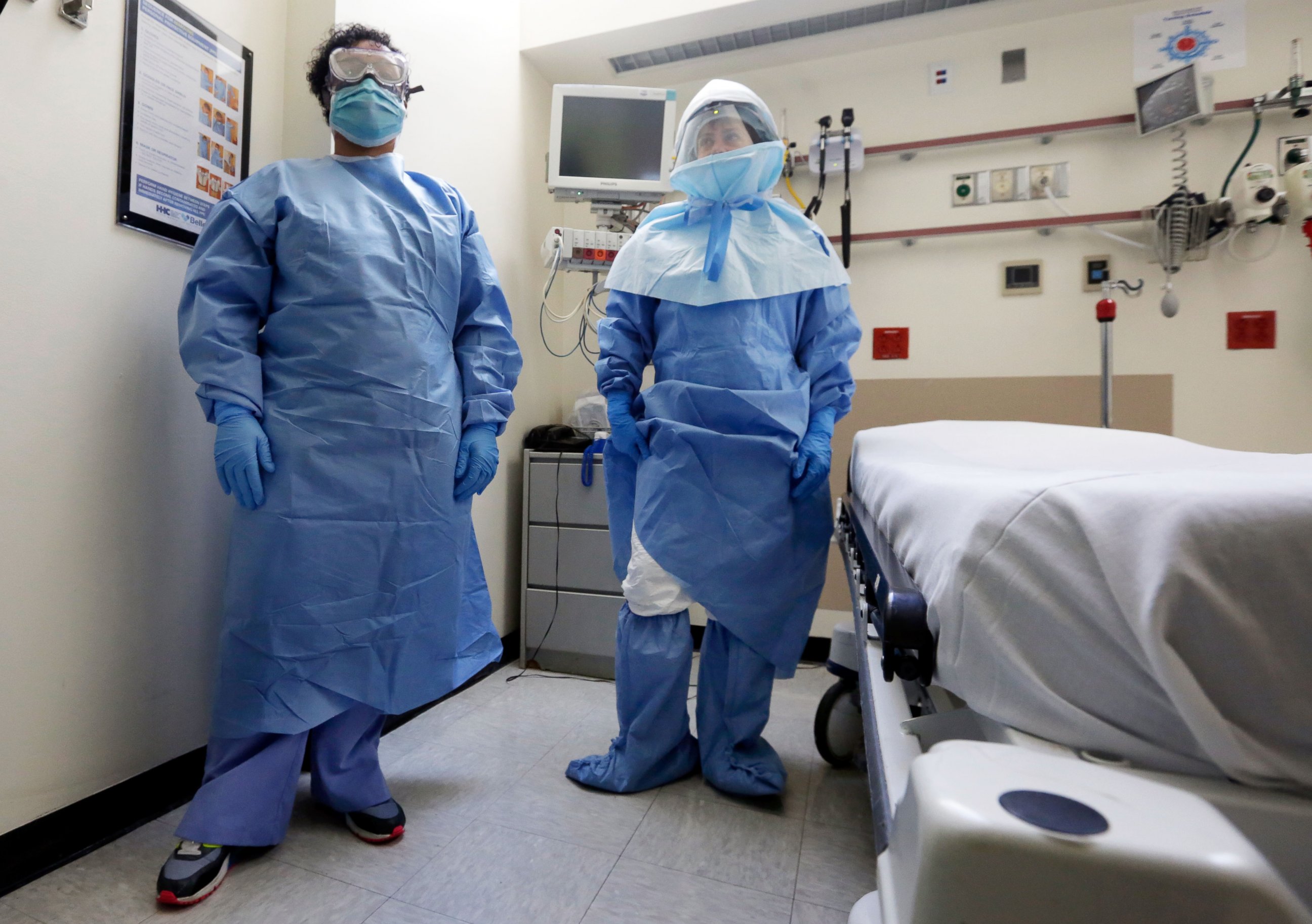 PHOTO: Belkys Fortune, left, and Teressa Celia, pose in protective suits in an isolation room during a demonstration of procedures for possible Ebola patients at Bellevue Hospital, New York, Oct. 8, 2014.