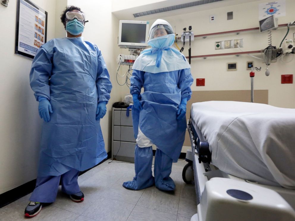 PHOTO: Belkys Fortune, left, and Teressa Celia, pose in protective suits in an isolation room during a demonstration of procedures for possible Ebola patients at Bellevue Hospital, New York, Oct. 8, 2014.