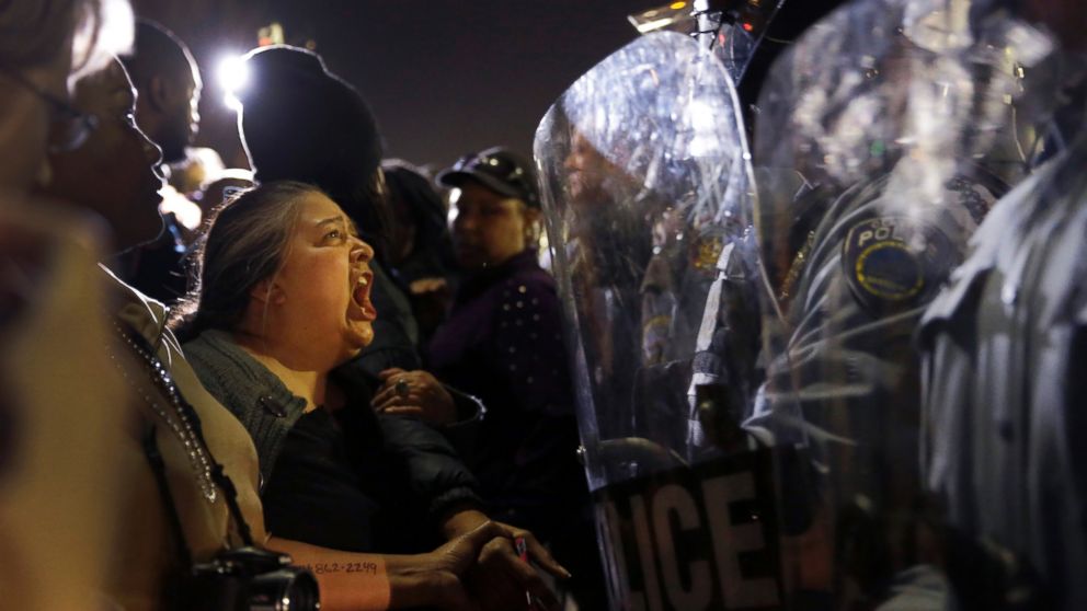 A protester yells at police outside the Ferguson Police Department, March 11, 2015, in Ferguson, Mo.