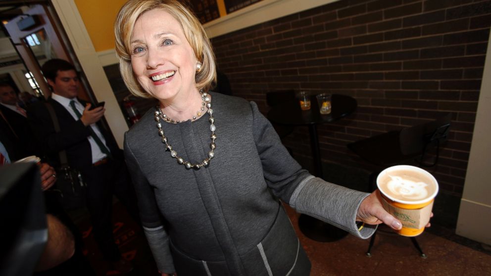 PHOTO: Hillary Clinton holds up her small white mocha latte with a logo of the coffee shop drawn in the foam as she campaigns for U.S. Sen. Mark Udall, during a stop in the newly-renovated Union Station in Denver on Oct. 13, 2014.
