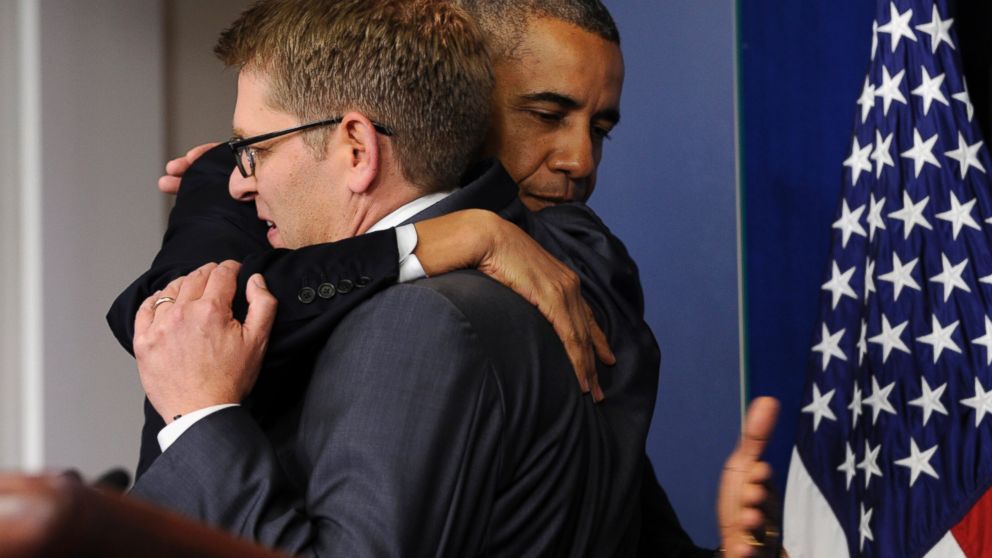 President Barack Obama gives White House press secretary Jay Carney a hug after announcing that Carney will step down later next month, during a surprise visit to the Brady Press Briefing Room of the White House, May 30, 2014. 