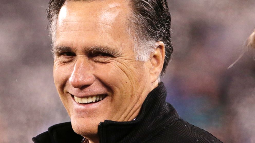 In this photo taken Dec. 1, 2014,  Mitt Romney smiles on the field before an NFL football game between the New York Jets and the Miami Dolphins in East Rutherford, N.J. 