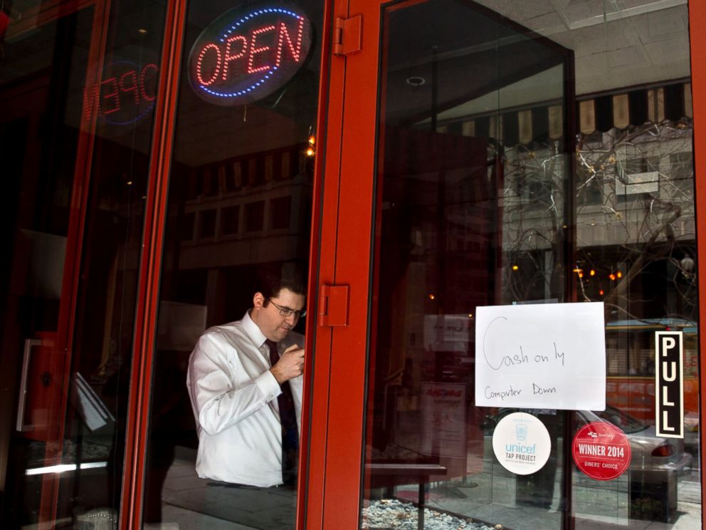 PHOTO: A man checks his cellphone in a restaurant, as power returns after a brief power outage, April 7, 2015, in Washington.