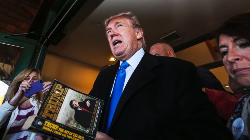 Republican presidential candidate Donald Trump autographs a book on his way out after speaking at a town hall meeting at the Atkinson Country Club in Atkinson, N.H., Oct. 26, 2015. 