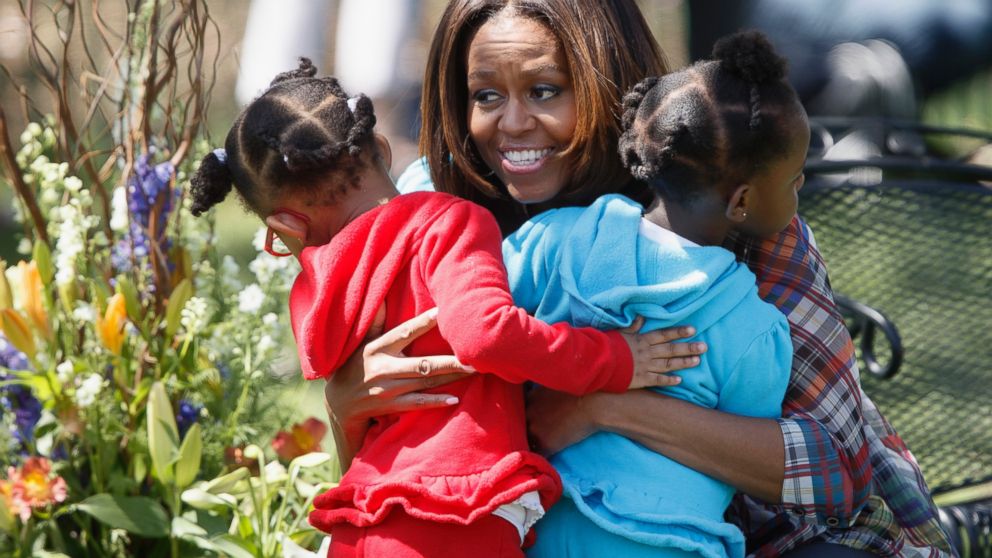 A a pair of youngster get a hug from first lady Michelle Obama after she read to children during the annual White House Easter Egg Roll, April 21, 2014, in Washington. 