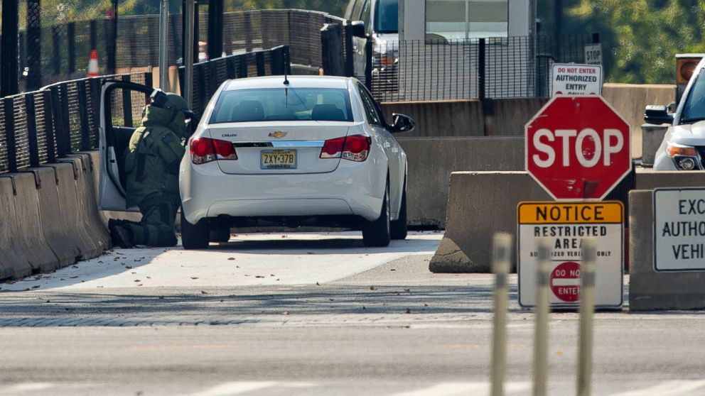 PHOTO: An explosive technician in a bomb suit kneels as he searches a vehicle near the entrance to White House in Washington, Saturday, Sept. 20, 2014.