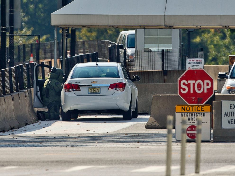 PHOTO: An explosive technician in a bomb suit kneels as he searches a vehicle near the entrance to White House in Washington, Saturday, Sept. 20, 2014.