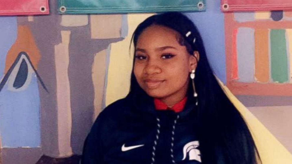 High School senior Arieyanna Williams stands in front a Michigan State flag as the college she's committed to in a hall at her elementary school in Chicago, Illinois.