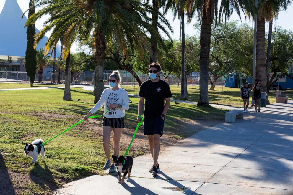 PHOTO: Chloe Flanders and Richard Milbauer wear protective face masks to prevent the spread of the coronavirus disease (COVID-19), in Tucson, Arizona, June 20, 2020.