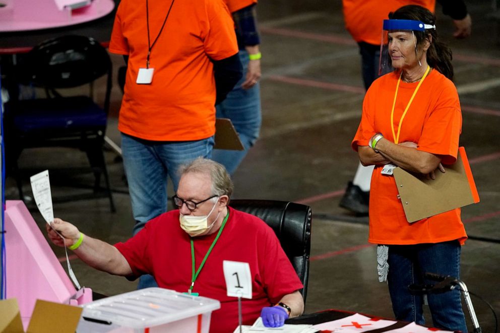 In this May 6, 2021, file photo, Maricopa County ballots cast in the 2020 general election are examined and recounted by contractors working for Florida-based company, Cyber Ninjas at Veterans Memorial Coliseum in Phoenix.