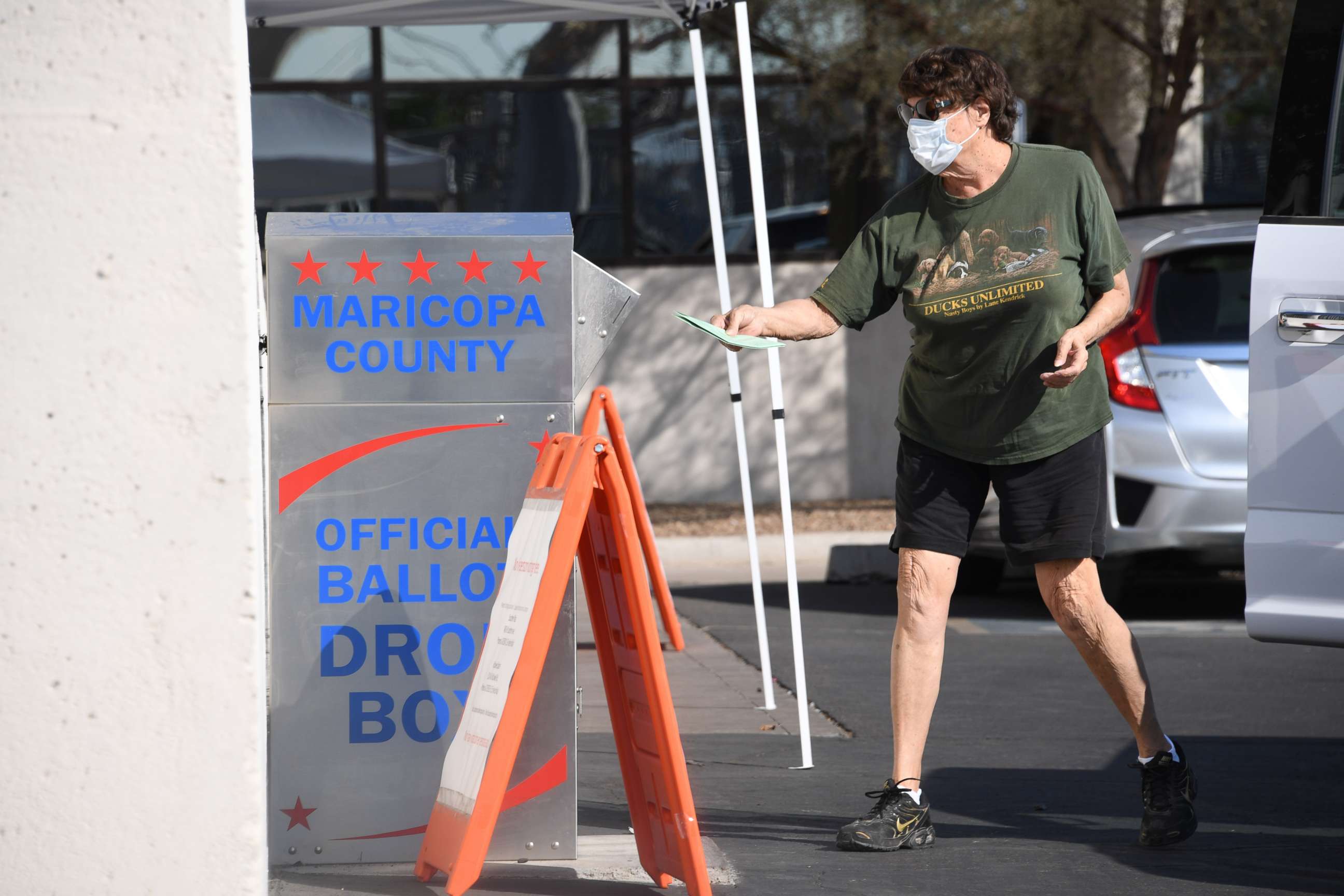 PHOTO: A voter deposits their mail-in ballot for the presidential election at a ballot collection box in Phoenix, Oct. 18, 2020.