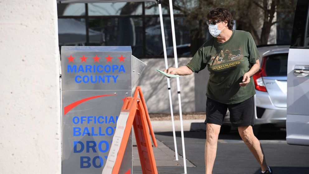 PHOTO: A voter deposits their mail-in ballot for the presidential election at a ballot collection box in Phoenix, Oct. 18, 2020.