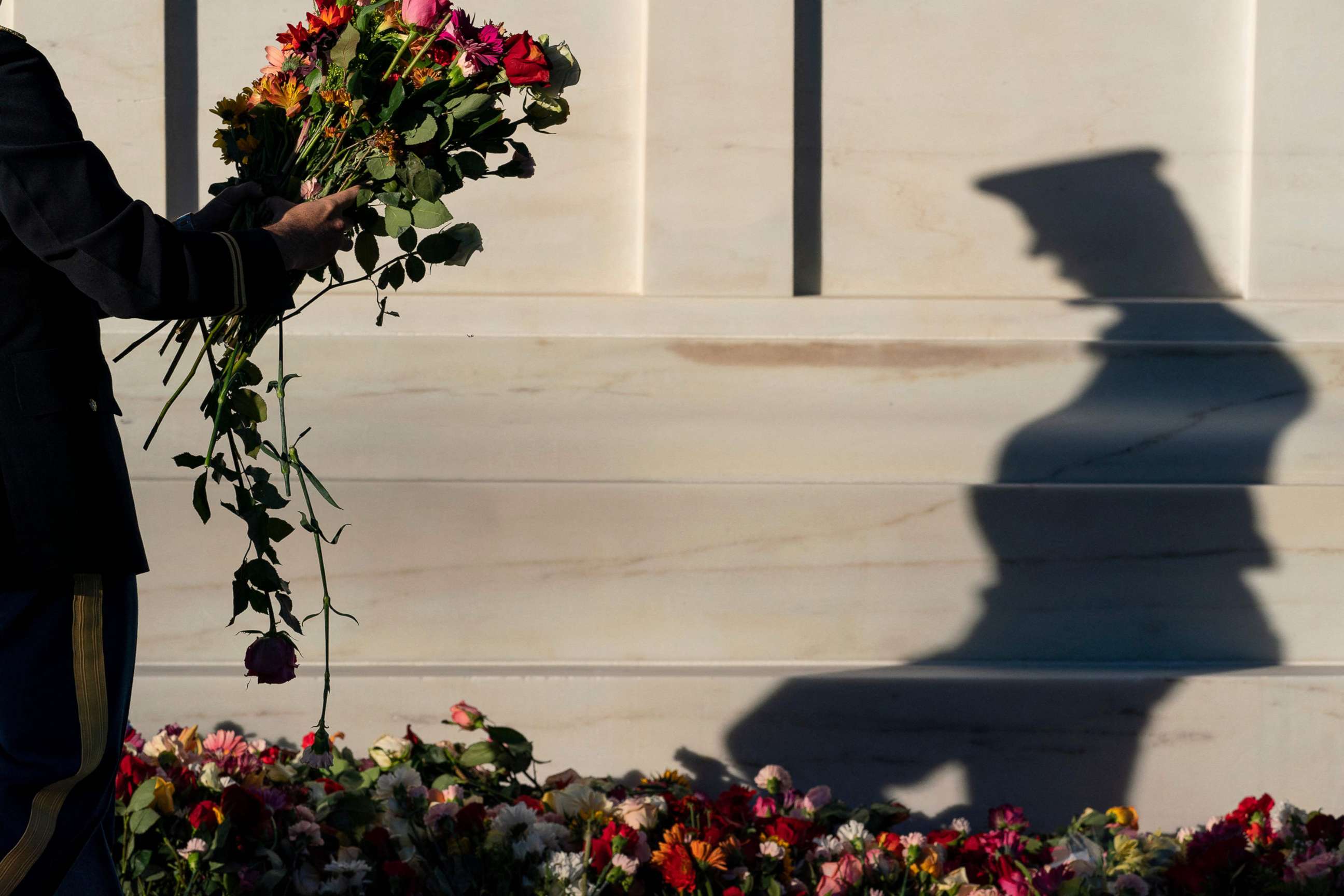 PHOTO: A soldier with the 3rd US Infantry Regiment, known as "The Old Guard," moves flowers during a centennial commemoration event at the Tomb of the Unknown Soldier, in Arlington National Cemetery, in Arlington, Va., Nov. 9, 2021.