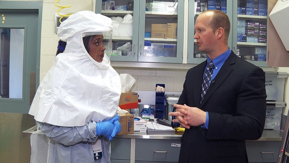 PHOTO: ABC News correspondent Rachel Scott tries on the special protective gear worn by researchers at Fort Detrick, Maryland when they work with the coronavirus.