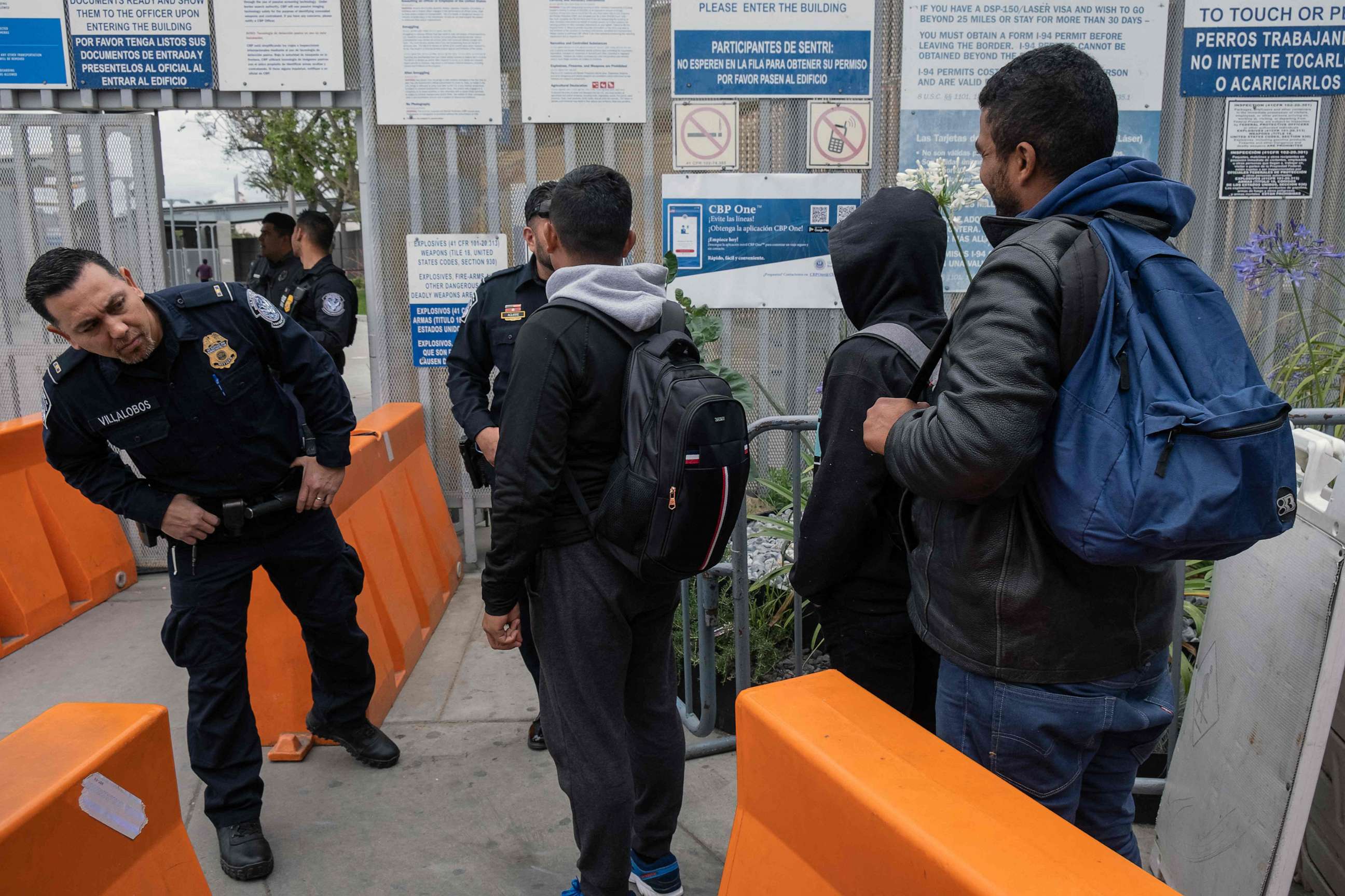 PHOTO: U.S. Customs and Border Protection agents allow asylum seekers from Venezuela to enter the country at the San Ysidro crossing port on the US-Mexico border, as seen from Tijuana, Baja California state, Mexico, May 31, 2023.