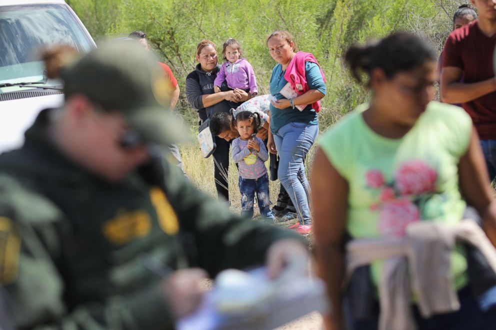 PHOTO: Central American asylum seekers wait as U.S. Border Patrol agents take them into custody on June 12, 2018 near McAllen, Texas. 