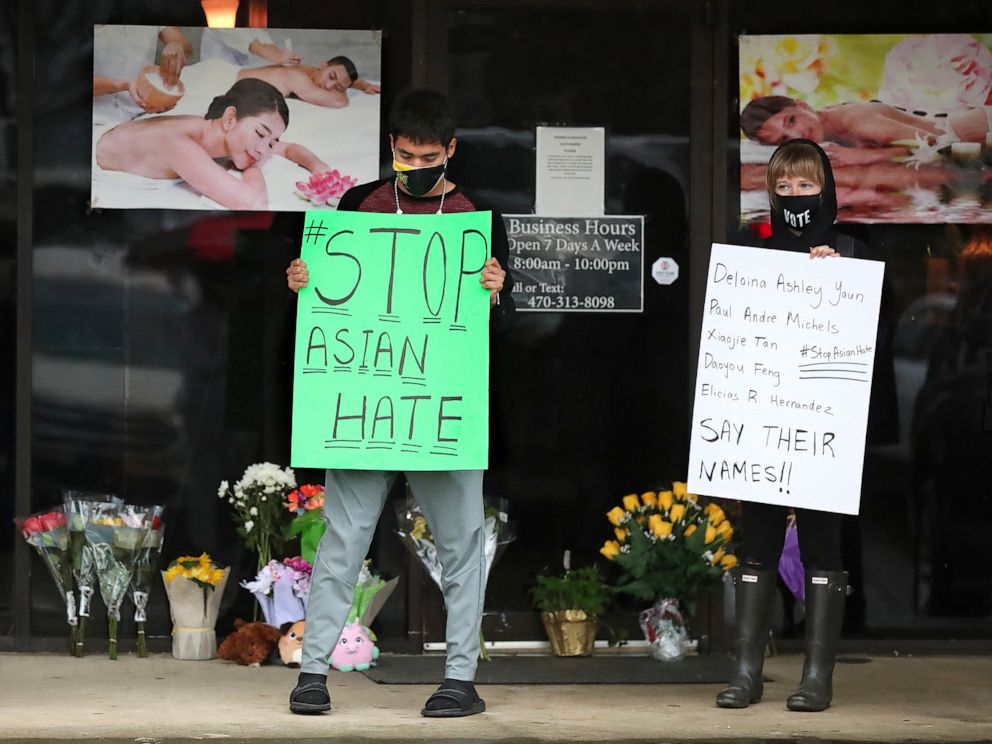 PHOTO: After dropping off flowers Jesus Estrella, left, and Shelby S., right, stand in support of the Asian and Hispanic community outside Young's Asian Massage parlor where four people were killed, March 17, 2021, in Acworth, Ga. 