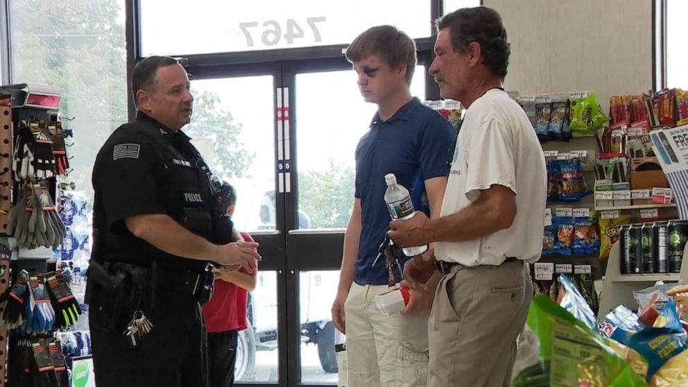 PHOTO: A police officer talks to a father and son who helped apprehend an armed gunman who attempted to rob a 7-11 store in Prince George's County, Md., Aug. 30, 2019.