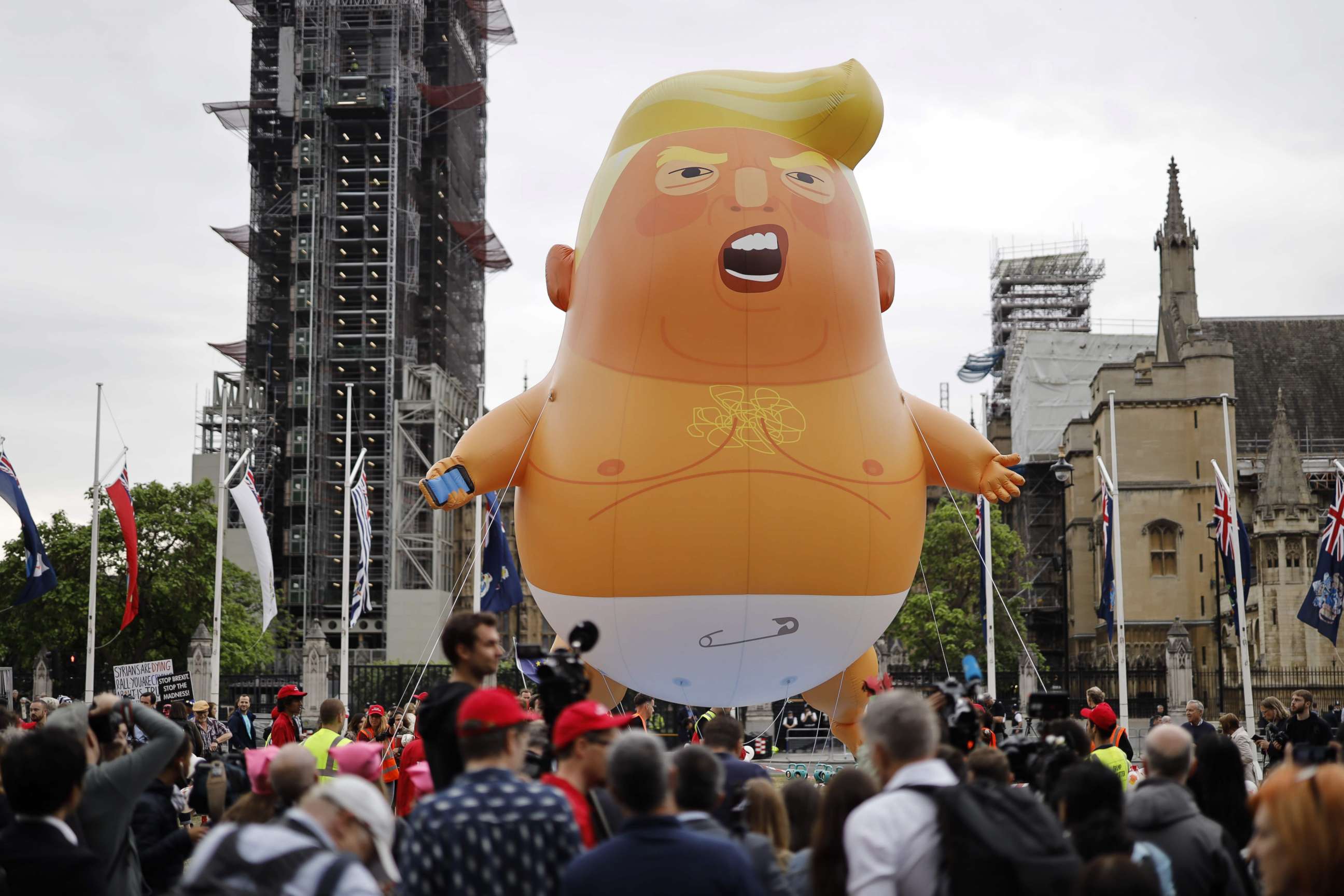 PHOTO: Anti-Trump demonstrators gather around an a giant balloon depicting President Donald Trump as an orange baby in Parliament Square in London, June 4, 2019.