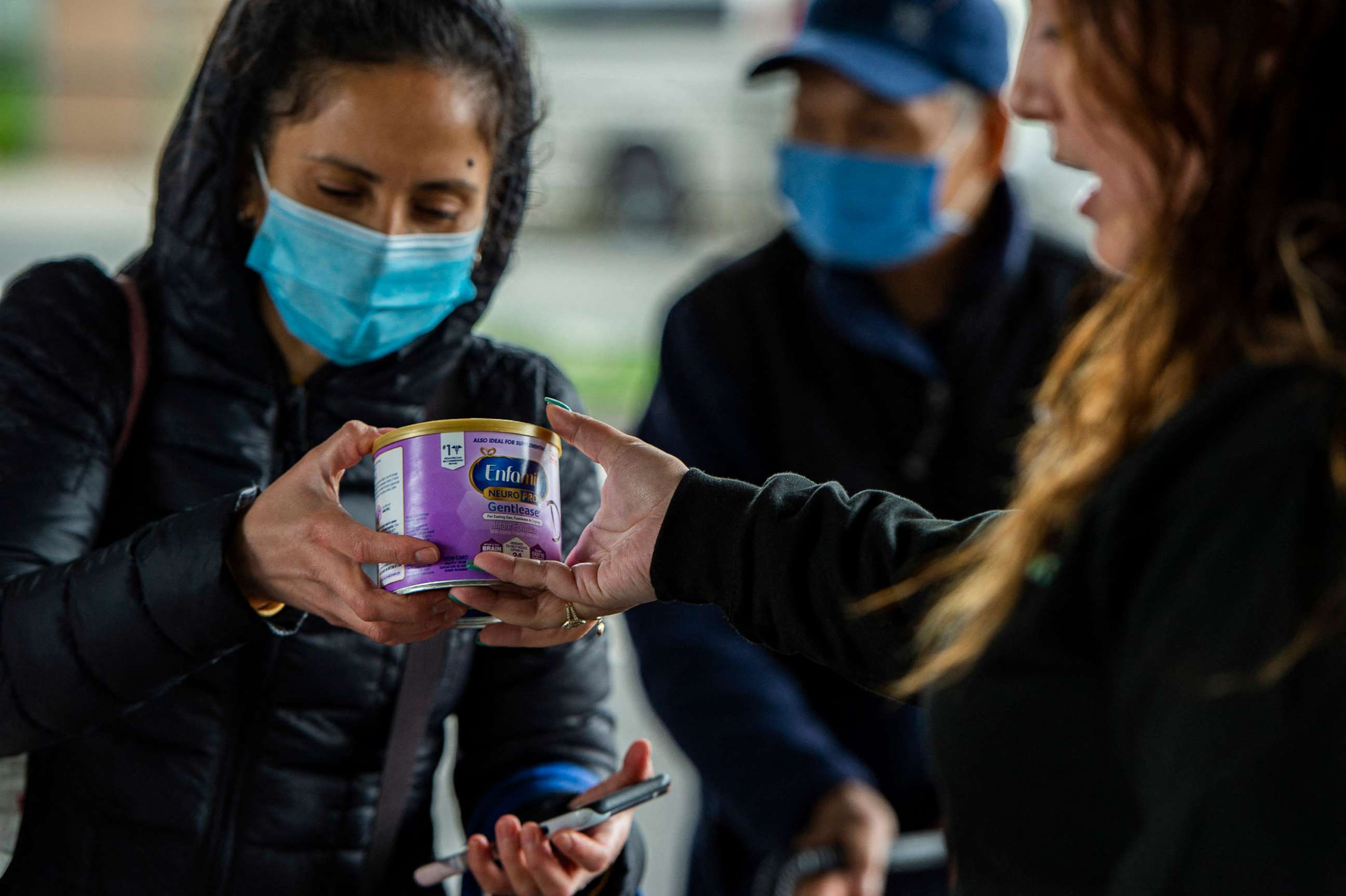 PHOTO: A worker hands gives a can of formula to a mother at a food pantry in Chelsea, Mass. on May 20, 2022.