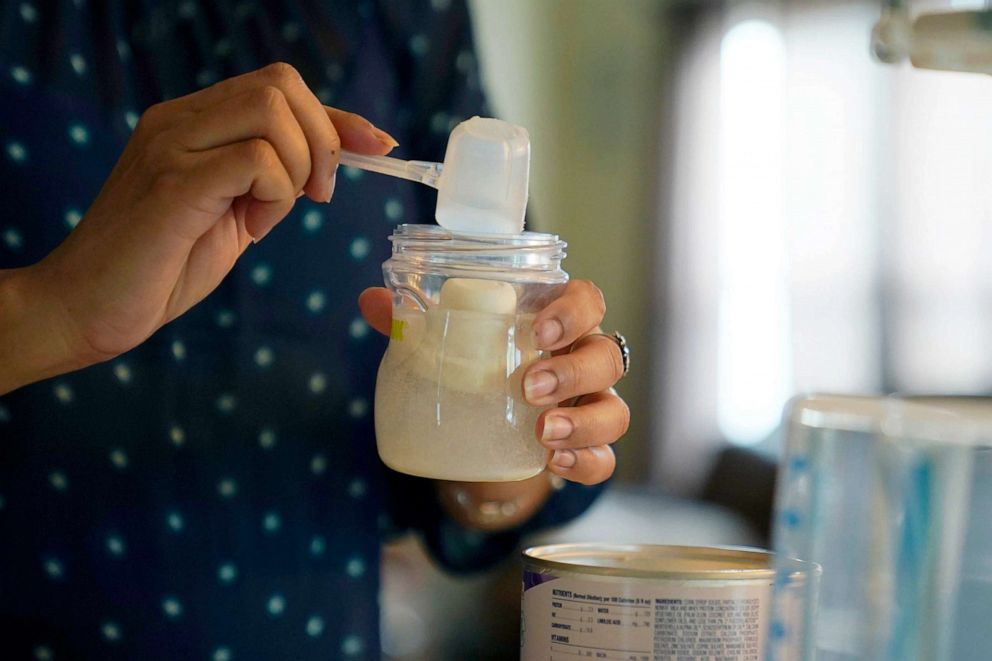 ẢNH: Olivia Godden chuẩn bị một bình sữa bột cho đứa con trai sơ sinh của cô tại nhà riêng ở San Antonio, Texas, ngày 13 tháng 5 năm 2022.