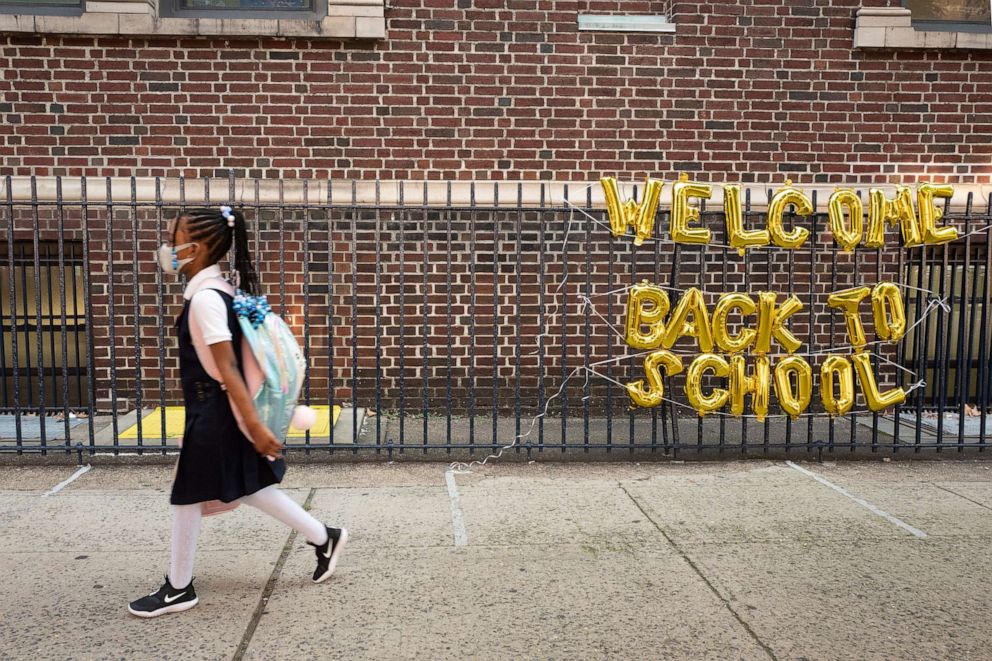 PHOTO: A girl passes a "Welcome Back to School" sign as she arrives for the first day of class at Brooklyn's PS 245 elementary school in New York, Sept. 13, 2021.