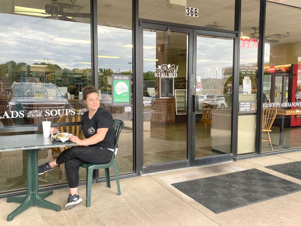 PHOTO: Caity Graham eats a meal on May 20, 2020 outside after her family's bakery, Old Mill Bread, which reopened for dine-in services on May 11, 2020 in Little Rock, Ark.