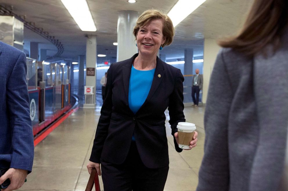 PHOTO: Sen. Tammy Baldwin, holding a cup of coffee, walks to the Senate Chamber on Capitol Hill for the impeachment hearing, in Washington, D.C., Jan. 22, 2020.
