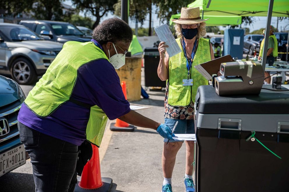 PHOTO: Workers drop voters ballots into a secure box at a ballot drop off location on Oct. 13, 2020, in Austin, Texas.