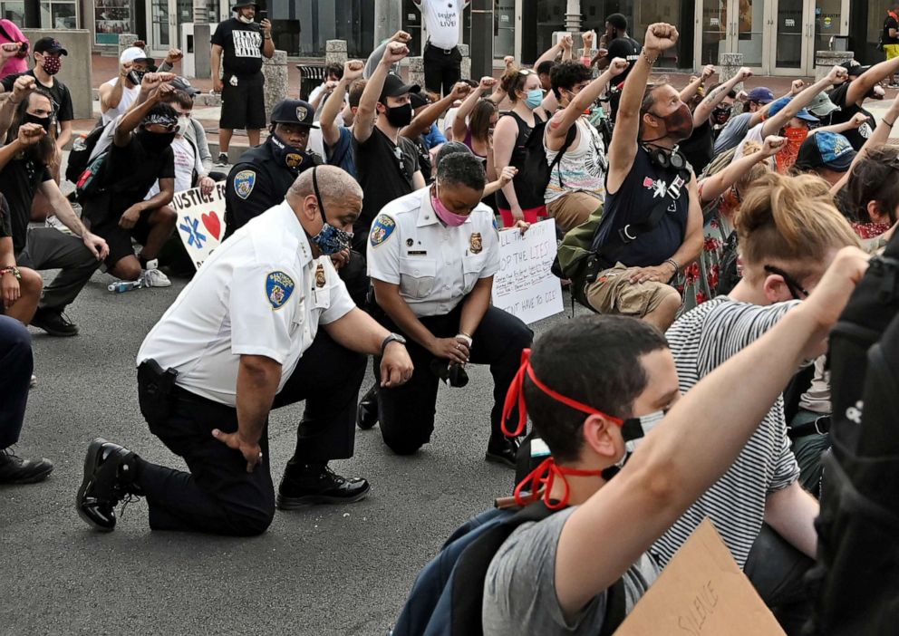 PHOTO: Baltimore City Police Commissioner Michael Harrison takes a knee with protestors as they halt their march for more than eight minutes to remember the time George Floyd struggled under the knee of a former Minneapolis police officer on June 4, 2020.
