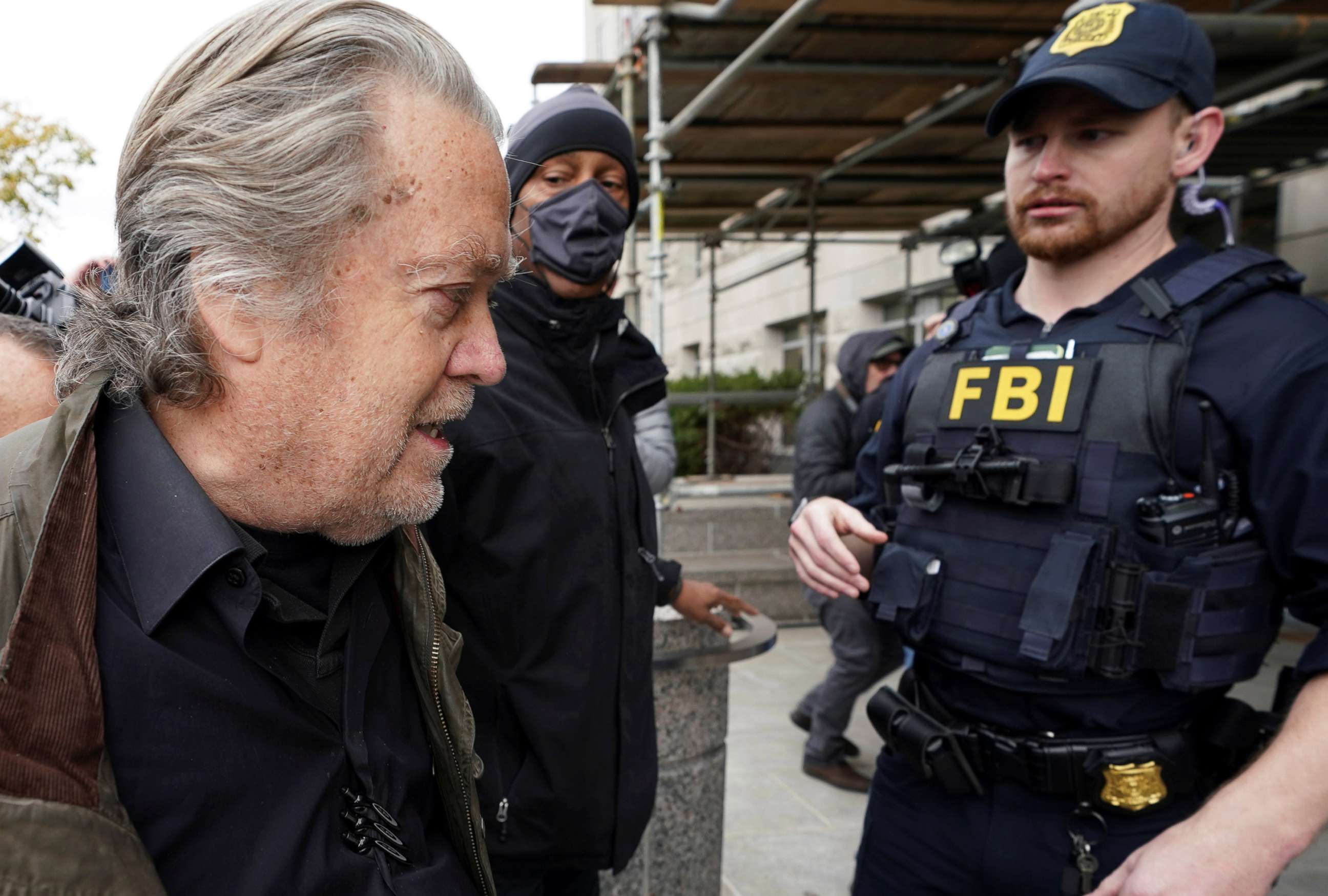 PHOTO: An FBI officer observes Steve Bannon, talk show host and former White House advisor to former President Donald Trump, as he arrives at the FBI's Washington field office to turn himself in to federal authorities in Washington, Nov. 15, 2021.