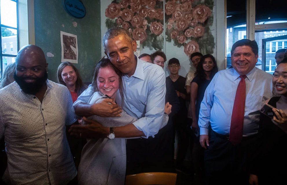 PHOTO: Former president Barack Obama gives a hug to Rachel Peterson as he makes a campaign stop at Caffe Paradiso with Democratic gubernatorial candidate J.B. Pritzker, right, after speaking at University of Illinois in Urbana, Ill., Sept. 7, 2018.