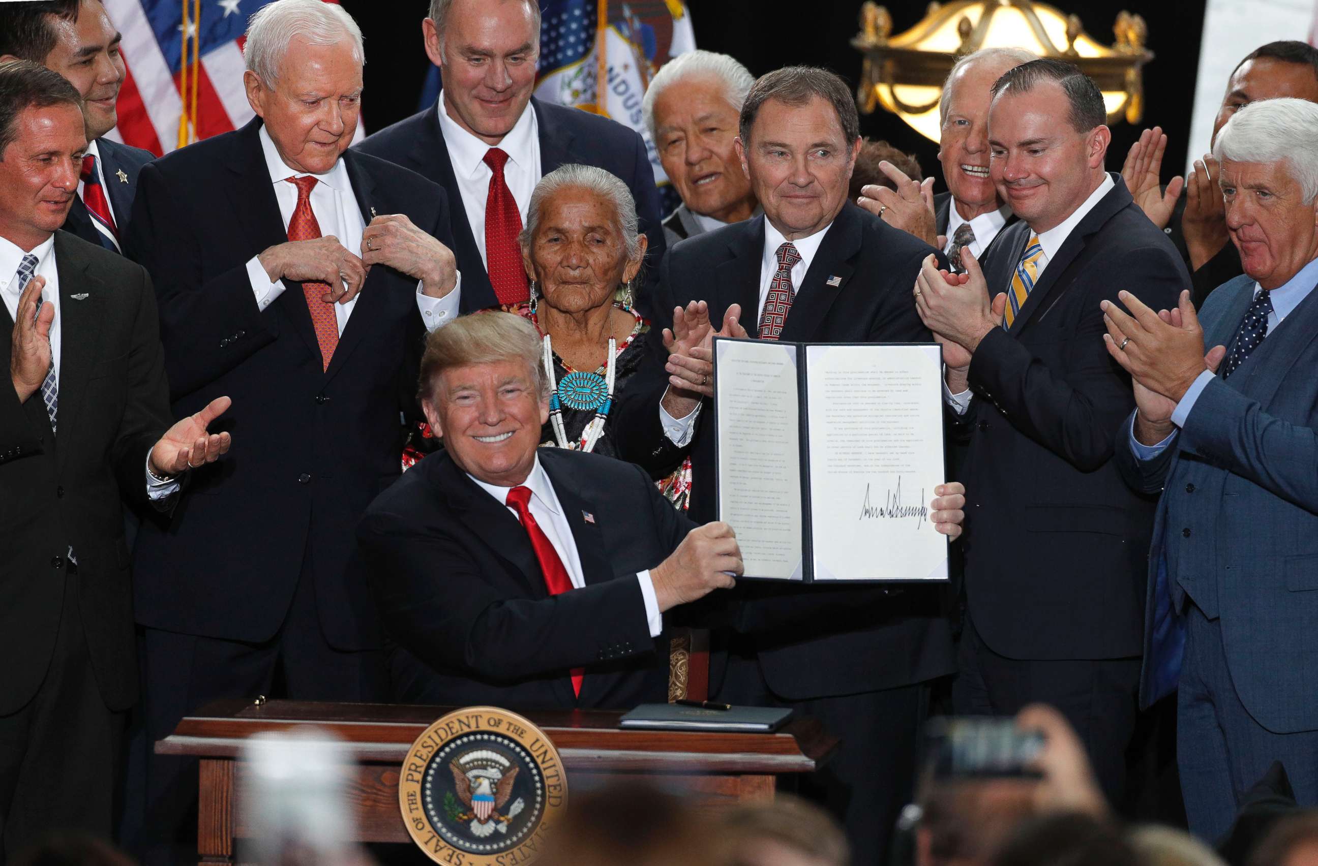 PHOTO: With Utah officials surrounding him, President Donald Trump shows an executive order he signed reducing the Grand Staircase-Escalante National Monument at the Rotunda of the Utah State Capitol, Dec. 4, 2017, in Salt Lake City, Utah. 
