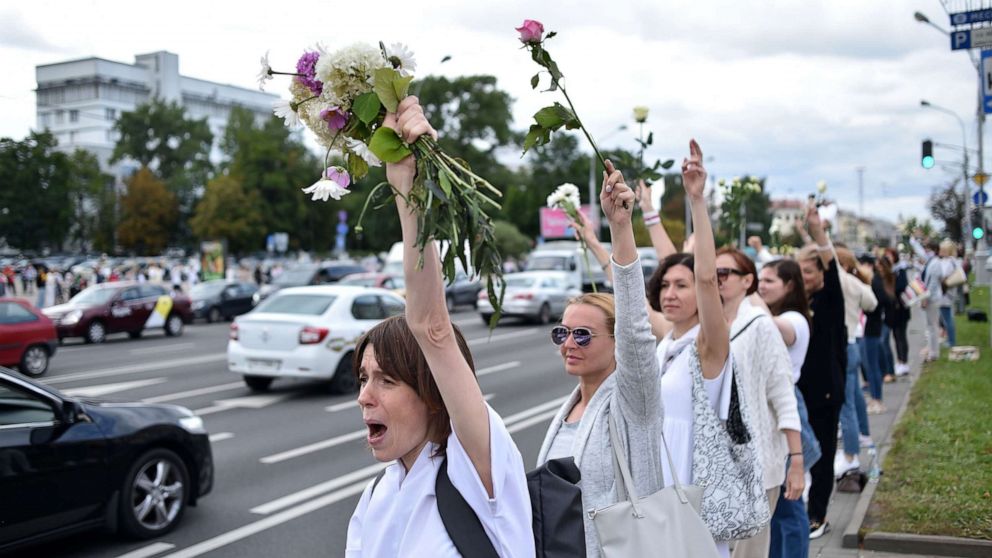 PHOTO: Women with flowers protest against police violence during recent rallies by opposition supporters, who accuse strongman Alexander Lukashenko of falsifying the polls in the presidential election, in Minsk, Belarus, on Aug. 13, 2020.