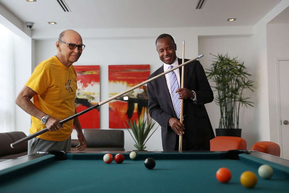 PHOTO: Housing and Urban Development Secretary Ben Carson plays pool with Armando de la Noval as he visits Colllins Park apartment complex on April 12, 2017 in Miami during a national listening tour.