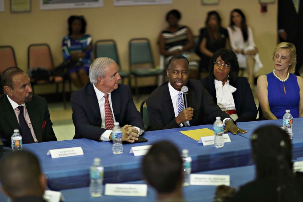 PHOTO: (L-R) Jorge Perez, CEO, Related Urban Group, Carlos Gimenez, mayor of Miami-Dade,  listen as U.S. Housing and Urban Development Secretary Ben Carson speaks during a visit to the Liberty Square apartment complex on April 12, 2017 in Miami. 