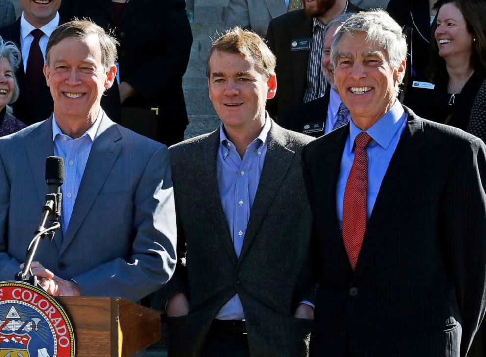 PHOTO: Senators Mark Udall, right, and Michael Bennet, center, stand with Colo. Gov. John Hickenlooper, during an event on the front steps of the state Capitol in Denver, March 14, 2014.