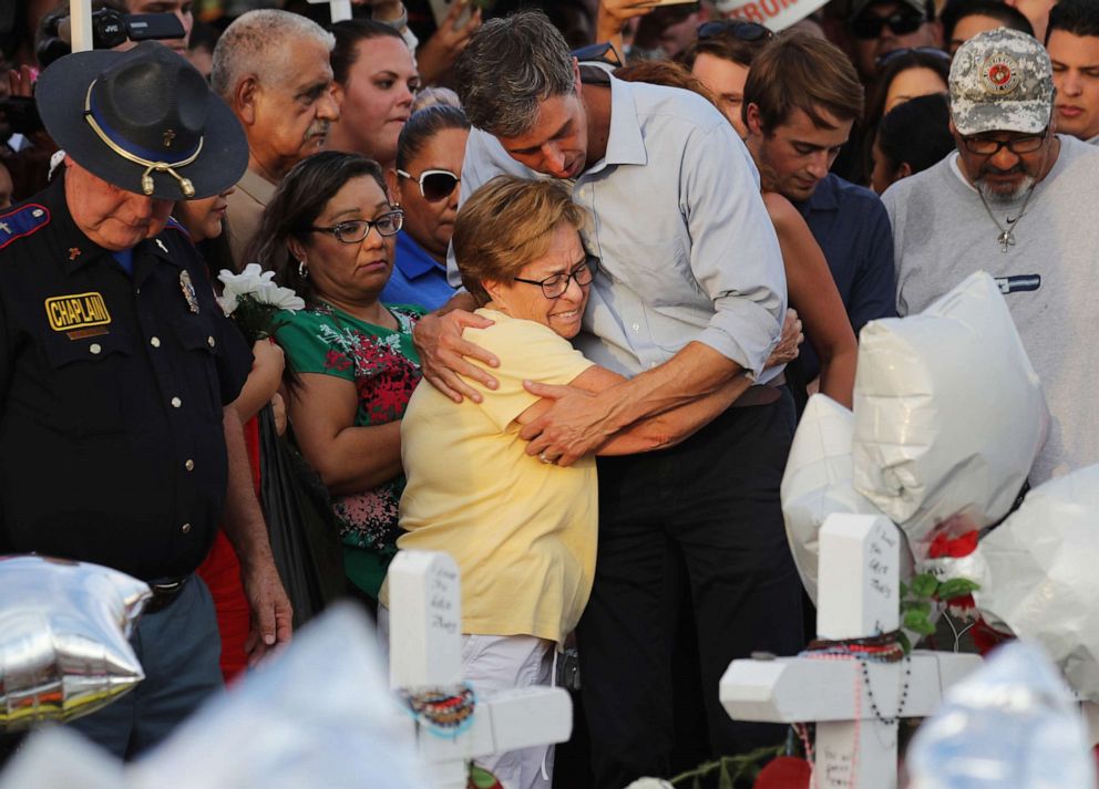 PHOTO: Democratic presidential candidate and former Rep. Beto O'Rourke hugs a woman at a makeshift memorial outside Walmart honoring victims of a mass shooting there which left 22 people dead, on August 7, 2019, in El Paso, Texas.