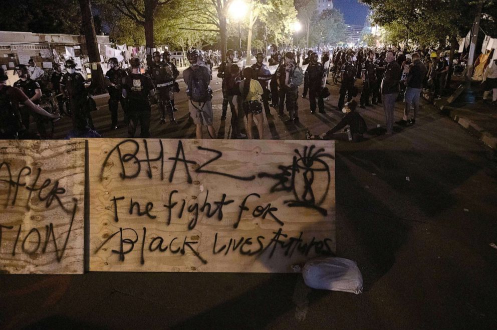 PHOTO: Protesters confront police near a barricade they erected and marked with the sign "Black House Autonomous Zone" in front of Lafayette Park near the White House, June 22, 2020.