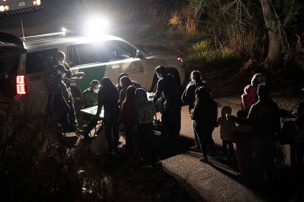 PHOTO: Asylum-seeking migrants' families wait to be transported by the U.S. Border Patrol after crossing the Rio Grande river into the United States from Mexico, April 22, 2021 in Roma, Texas.